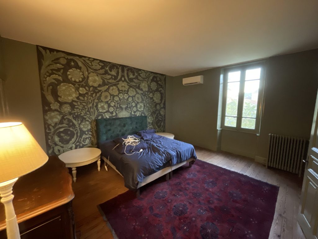 Chambre rénovée : murs peints en vert et panneau mural décoratif