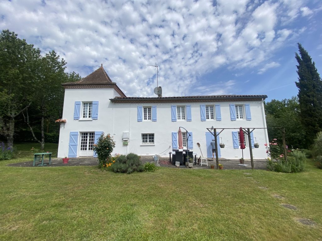 Façade de maison repeinte en blanc avec volets bleu lavande
