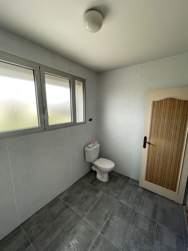Salle de bains : panneaux muraux et grand carrelage gris