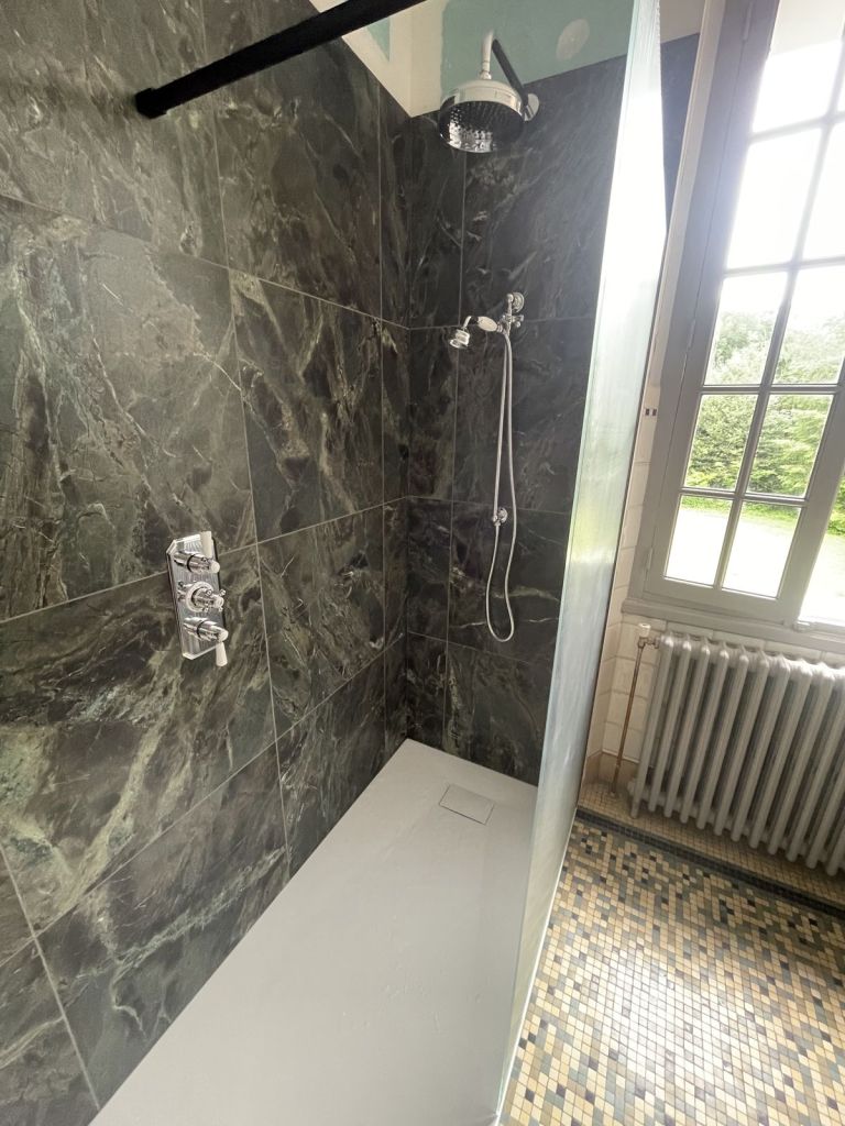 Douche avec robinetterie noire et panneaux effet marbre