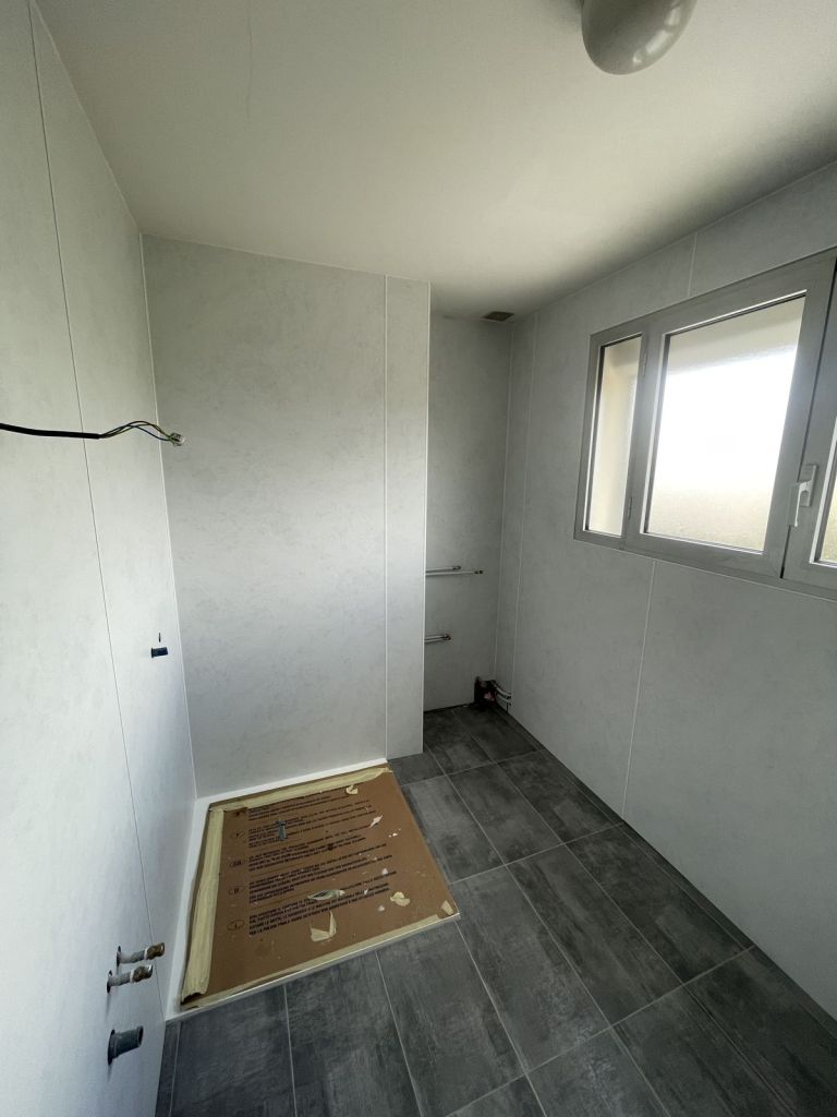 Salle de bains : panneaux muraux et receveur de douche posés