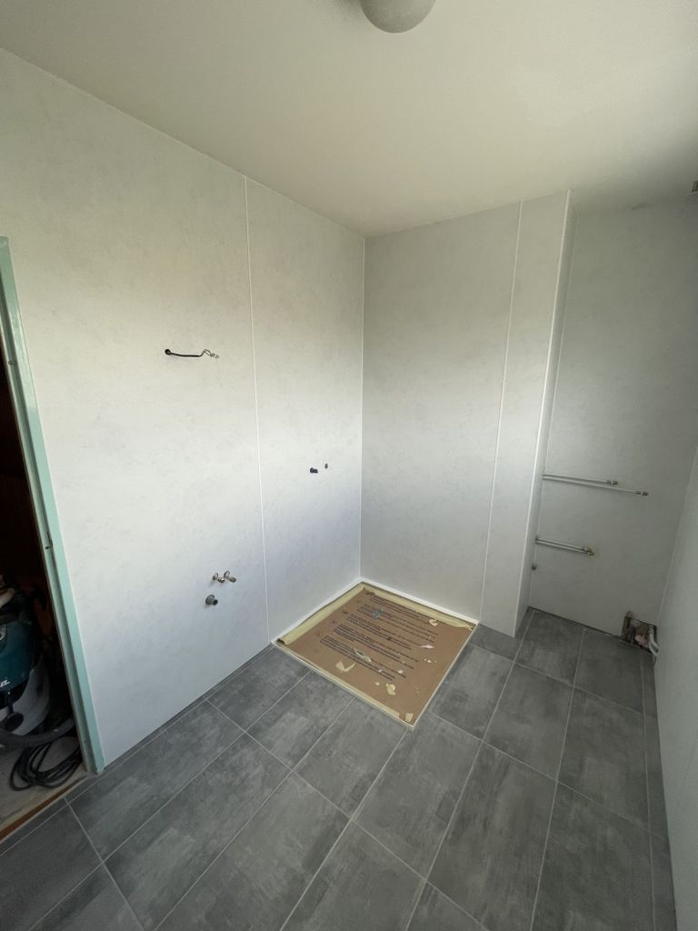 Salle de bains en cours : panneaux muraux et receveur protégé